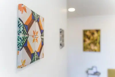 a bathroom with a tile wall with two pictures at GuestReady – Quaint Retreat in Funchal in Funchal