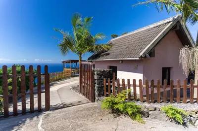 a house on a hill with the ocean in the background at Sunset Village by Holiday Rental Madeira in São Jorge