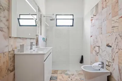 a white bathroom with a sink and a toilet at Casa dos Leões in Arco da Calheta