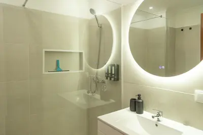 a bathroom with a sink and a shower with mirrors at Villa Rita in Machico in Machico