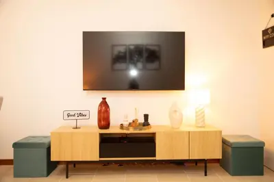 a living room with a table with a tv on the wall at Villa Rita in Machico in Machico
