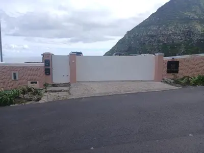 a white fence with a mountain in the background at Sao Lourenco in Caniçal