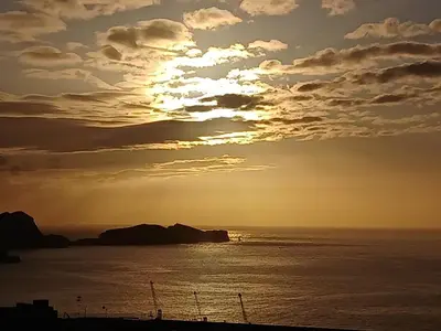 a sunset over the ocean with the sun in the sky at Sao Lourenco in Caniçal