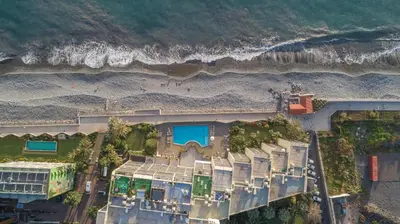 an aerial view of a building with a beach at flowers island house 8 infinity in Funchal
