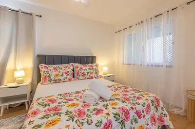 a bedroom with a bed with a floral bedspread at flowers island house 8 infinity in Funchal