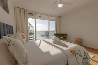 a bedroom with a white bed with a view of the ocean at flowers island house 8 infinity in Funchal