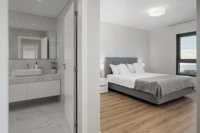 a white bedroom with a bed and a sink at Saraiva Hills I by An Island Apart in Câmara de Lobos