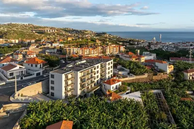 an aerial view of a city with buildings and the ocean at Saraiva Hills I by An Island Apart in Câmara de Lobos