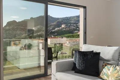 a living room with a couch and a large window at Saraiva Hills I by An Island Apart in Câmara de Lobos