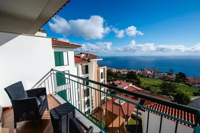 a balcony with chairs and a view of the ocean at SkyView Penthouse Apartment in Caniço