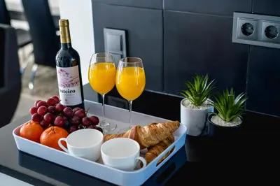 a tray with a bottle of wine and two glasses at SkyView Penthouse Apartment in Caniço