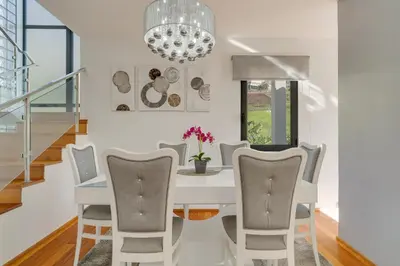 a dining room with a white table and chairs at Countryside Charm House by Holiday Rental Madeira in Câmara de Lobos