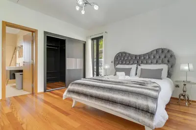 a bedroom with a large bed with a gray headboard at Countryside Charm House by Holiday Rental Madeira in Câmara de Lobos