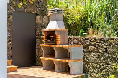 a brick oven sitting next to a stone wall at villa vista do vale in São Vicente