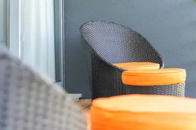 a wicker chair with a reflection in a mirror at villa vista do vale in São Vicente