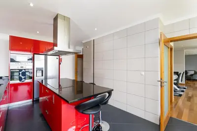 a kitchen with red cabinets and a black counter top at villa vista do vale in São Vicente