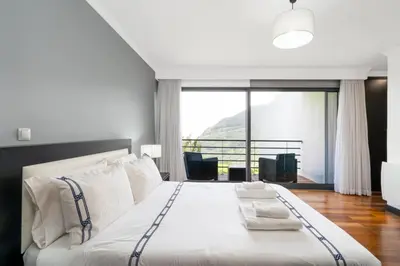 a bedroom with a large bed with a large window at villa vista do vale in São Vicente