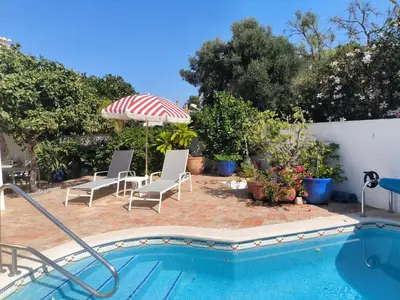 a swimming pool with two chairs and an umbrella at Luz Bay Club 29 in Luz