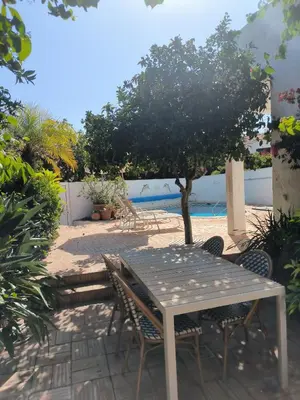 a table and chairs with a tree and a pool at Luz Bay Club 29 in Luz