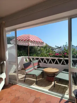 a patio with a table and chairs and an umbrella at Luz Bay Club 29 in Luz
