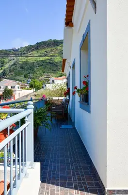 a balcony of a house with a table and chairs at Teixeira House in Arco da Calheta