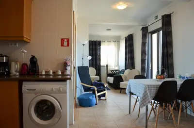 a kitchen and living room with a table and a dining room at Teixeira House in Arco da Calheta