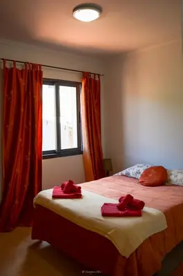 a bedroom with a bed with red towels on it at Teixeira House in Arco da Calheta