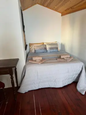 a bed in a room with a wooden floor at Teixeira House in Arco da Calheta