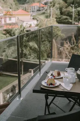 a table with two plates of food on a balcony at Bela Vista House in Ponta Delgada