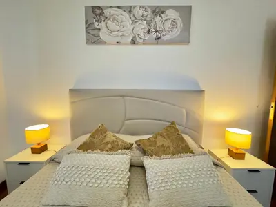 a bedroom with a white bed with two lamps at Bela Vista House in Ponta Delgada