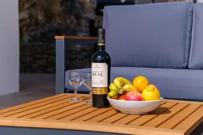 a bottle of wine and a bowl of fruit on a table at GuestReady - Madeiran oasis with ocean view in Campanário