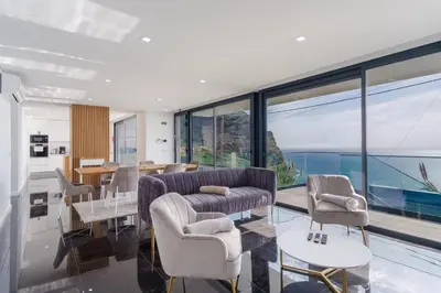 a living room with a couch and chairs and windows at GuestReady - Madeiran oasis with ocean view in Campanário