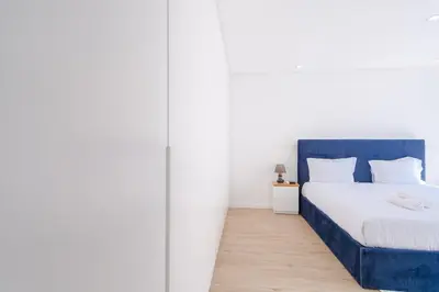 a bedroom with a blue bed and white walls at GuestReady - Madeiran oasis with ocean view in Campanário