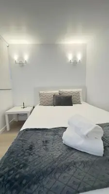a bedroom with a large bed with white sheets at Like Home IV - Ideal for families and friends in Funchal