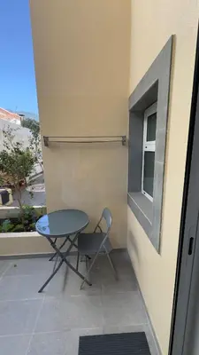 a table and a chair sitting on a balcony at Like Home IV - Ideal for families and friends in Funchal