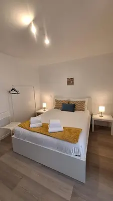 a bedroom with a large white bed with two lamps at Like Home V - single room in Funchal