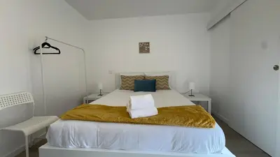a white bedroom with a large bed with a gold blanket at Like Home V - single room in Funchal