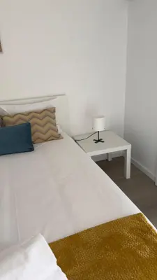 a bedroom with a large white bed and a table at Like Home V - single room in Funchal