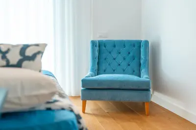 a blue chair in a room with a bed at Suite 5P Madeira Acqua Residence in Funchal