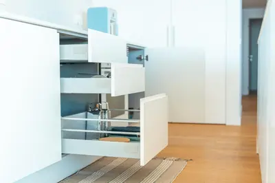 an open kitchen with white cabinets and a wooden floor at Suite 5P Madeira Acqua Residence in Funchal