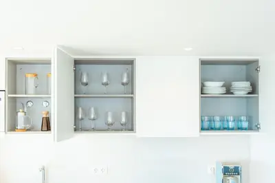 a kitchen cabinet with wine glasses and dishes at Suite 5P Madeira Acqua Residence in Funchal