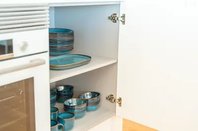 a kitchen pantry with blue dishes on shelves at Suite 5P Madeira Acqua Residence in Funchal