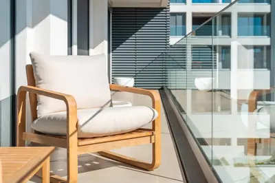 a chair on a balcony with a table at Suite 5P Madeira Acqua Residence in Funchal