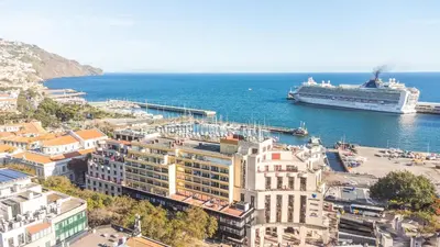 a cruise ship is docked at a harbor at Tropical Sun by Atlantic Holiday in Funchal