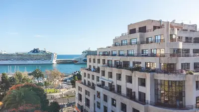 a tall building with a cruise ship in the water at Tropical Sun by Atlantic Holiday in Funchal