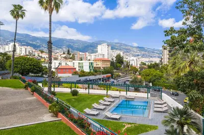 a park with a swimming pool and a city at Pestana Quinta Perestrello in Funchal