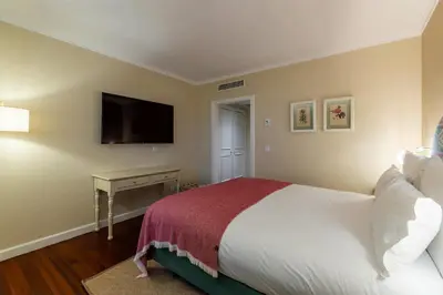a bedroom with a bed and a television on the wall at Pestana Quinta Perestrello in Funchal