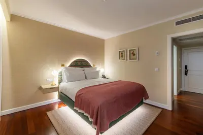 a bedroom with a large bed with a red blanket at Pestana Quinta Perestrello in Funchal