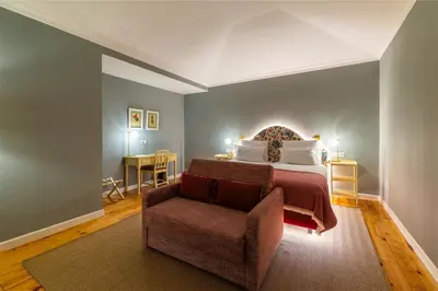 a bedroom with a bed and a chair in a room at Pestana Quinta Perestrello in Funchal