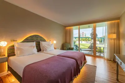 a hotel room with a large bed and a balcony at Pestana Quinta Perestrello in Funchal